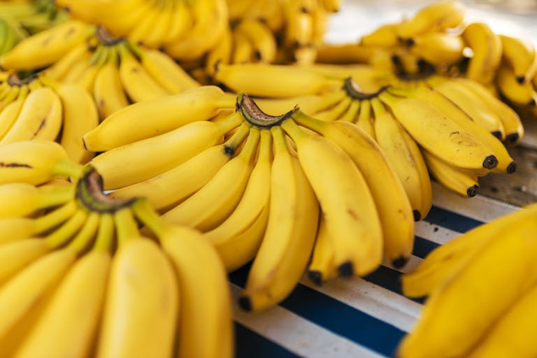 Bunches of ripe yellow bananas displayed on a market stall. Perfect for healthy eating concepts.